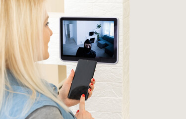 Naklejka premium Protection of private residential building with help of an external video surveillance system. an application on smartphone screen. CCTV view of burglar breaking into home