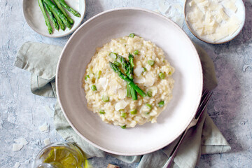 Italian risotto with asparagus and parmesan cheese on table. Top view. - obrazy, fototapety, plakaty