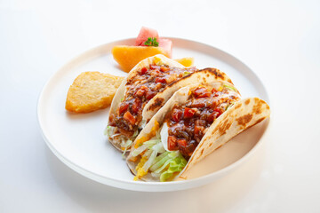 Soft shell delicious tacos for breakfast with hash brown and seasonal fruits.