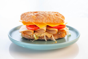 Bologna meat ciabatta sandwich served in a blue plate.