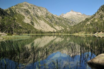 The lake surrounded by mountains reflecting on the water surface in the French Pyrenees