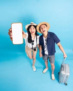 Asian couple traveling image  isolated on blue background