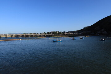 A scene of Togetsu-kyo Bridge and Nakanoshima-koen Park and Hozu-gawa River at Arashiyama in Kyoto City in Japan 日本の京都市嵐山にある中ノ島公園と渡月橋と保津川の風景