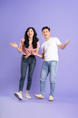 Fototapeta premium full body image of asian couple posing on purple background