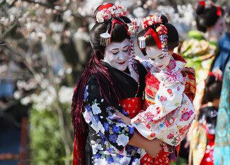 Nice lady with a small girl in her arms - Two Maiko, chief and junior, the apprentice Geisha,...