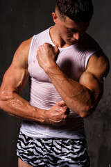 Athlete bodybuilder trains in the studio in the rain.