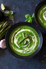 Asparagus cream soup on dark table. Healthy food. Top view.
