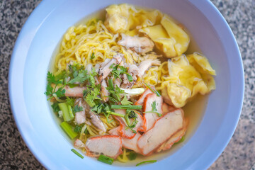 Egg noodles and pork wonton soup with red roasted pork, and crab meat dumplings, vegetables are delicious street food in Thailand.