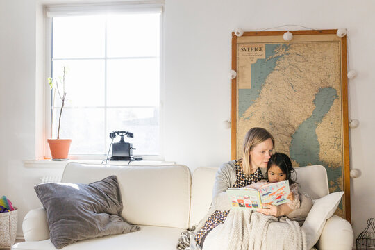 Mother and daughter (4-5) reading book