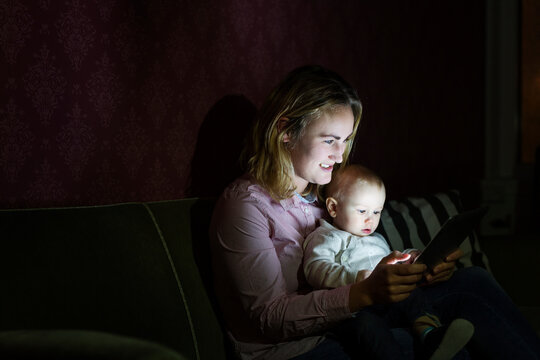 Mother with baby son (6-11 months) using tablet