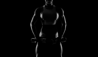 Fototapeta na wymiar Black and white image of a sports girl on a black background. Fitness concept.