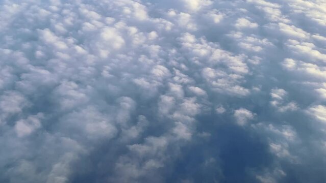 Breathtaking flight above white fluffy clouds over blue sea