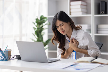 Asian women are stressed or has sore throat at office while working on laptop, Tired asian businesswoman with headache at office, feeling sick at work, copy space