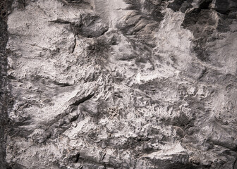 Stone texture of an old rough building wall with cracks, reliefs, plots. Random pattern