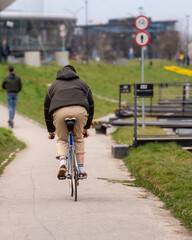 A cyclist rides a sports bike on an asphalt bike path in the city on a spring day, urban healthy lifestyle, a man on a bike, sustainable and eco-friendly urban transport