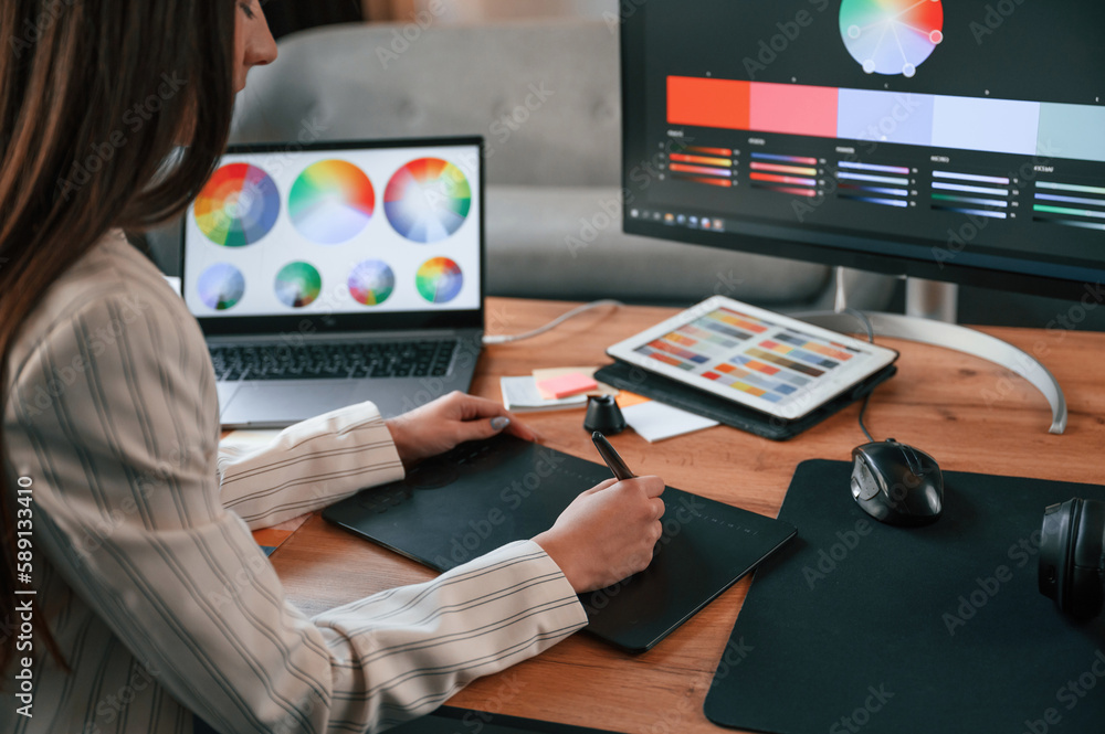 Poster drawing by using graphic tablet. woman is working in the modern office with computer