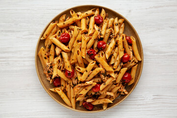 Homemade One-Pot Spinach and Tomato Pasta on a Plate on a white wooden background, top view. Flat lay, overhead, from above.