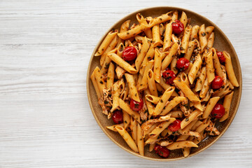Homemade One-Pot Spinach and Tomato Pasta on a Plate on a white wooden background, top view. Flat lay, overhead, from above. Copy space.