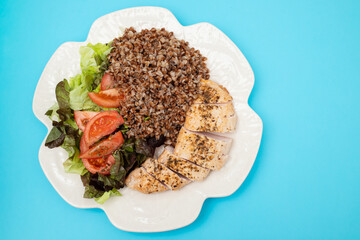 Baked turkey with buckwheat and vegetable fresh salad on plate