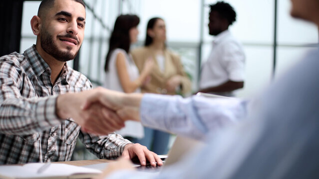 Young adult caucasian male, hiring manager, sits at a desk in a modern office