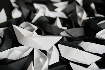 Levitating white and black paper ships