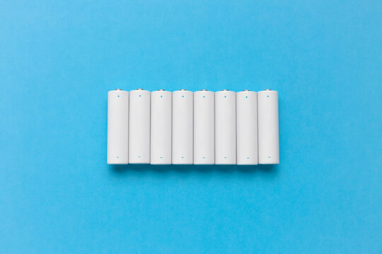 Row of white batteries on blue background