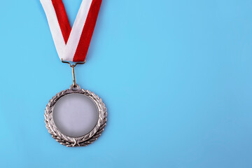Gold medal 1 place with a ribbon on a light blue background, the concept of victory or success - 589143038