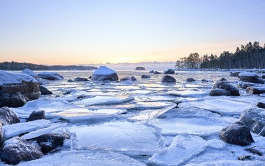 Beautiful view of a frozen lake with trees in the background at sunset