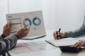 Young colleagues discussing business and price chart analyzes business people on the table great in...