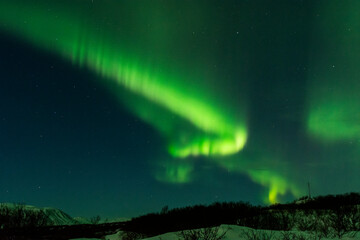 Fototapeta na wymiar imagen de un paisaje nocturno nevado con una aurora boreal en el cielo de Islandia 