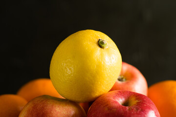 Fruit in a reusable bag. Earth day and zero waste concept. Orange, lemon and apple close-up on a dark background