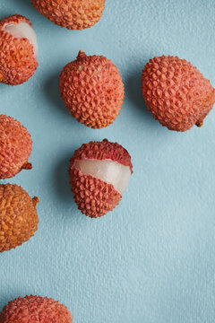 Fresh and cut open ripe lychee fruit on smooth surface