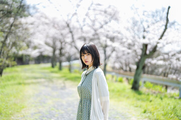 桜の花を見るショートヘアの女性