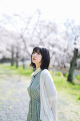 桜の花を見るショートヘアの女性