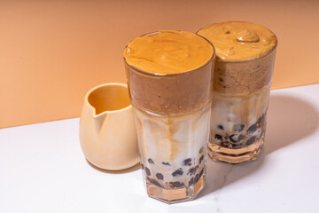 Boba dalgona coffee. Trendy asian latte morning drink with whipped instant coffee and tapioca pearl balls, summer thai bubble cocktail glass in sunny background