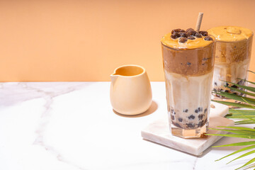 Boba dalgona coffee. Trendy asian latte morning drink with whipped instant coffee and tapioca pearl balls, summer thai bubble cocktail glass in sunny background