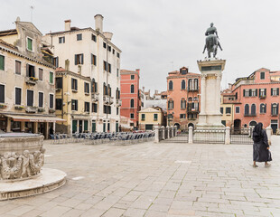 Fototapeta na wymiar Piazza in Venice Italy with statue and nun walking by
