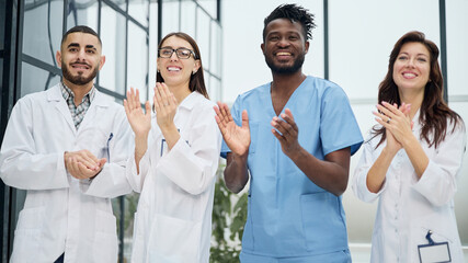 Fototapeta na wymiar Successful team of different doctors clapping hands