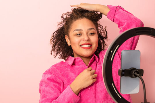Calm ethnic woman demonstrating hairstyle during beauty tutorial