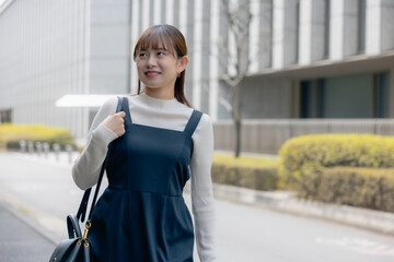 Young Asian career woman walking in a residential area.