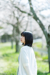 桜の花を見るショートヘアの女性