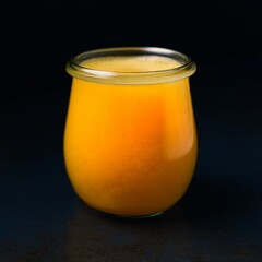 Glass of fresh orange juice on a dark background