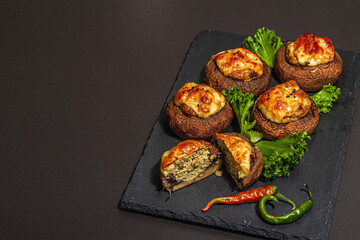 Baked stuffed mushroom caps ready for eating. Champignons, spices, vegetables, cheese
