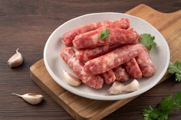Raw Taiwanese sausage in garlic flavor in a plate on wooden table background.