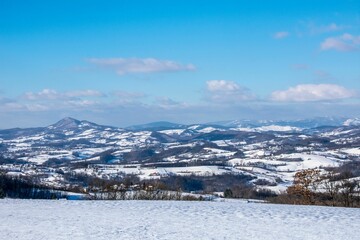 Landscape view of the snow-covered area with hills in the background against a blue sky