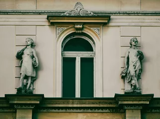 Photo sur Plexiglas Monument historique Old baby sculptures in front of the ancient building entrance