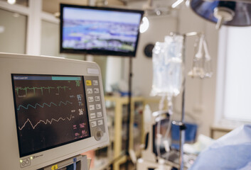 Electrocardiogram in hospital surgery operating emergency room showing patient heart rate with blur team of surgeons background