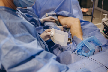 Surgeons operate on the legs of an elderly woman with varicose veins.