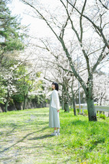 桜の花を見るショートヘアの女性