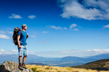 Fototapeta na wymiar Successful hiker observing on mountain peak cliff edge. New Zealand